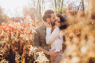 Portrait of a young couple in the autumn forest, a guy and a girl cuddling in the outdoor