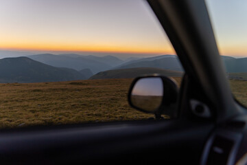 Off-road car in the mountains at sunrise