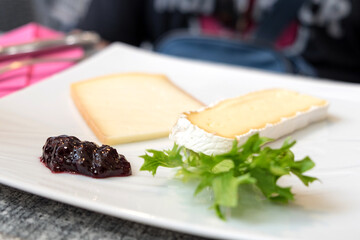 Traditional dessert of Languedoc-Roussillon (Occitanie) region of France - blue farm Brie cheese served with homemade fruit jam, fresh grapes or figs.