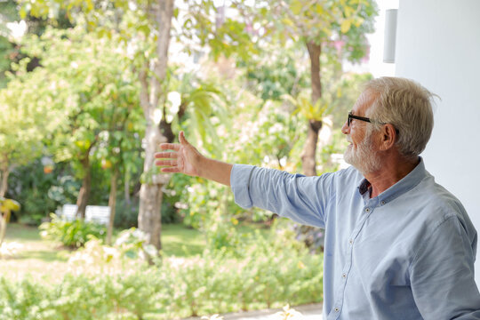 A senior retirement grandfather enjoy the gardan in his house backyard