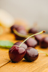 close up view of ripe sweet cherries on wooden surface