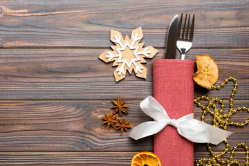 Fototapeta na wymiar Top view of utensils on festive napkin on wooden background. Christmas decorations with dried fruits and cinnamon. New year dinner concept with copy space
