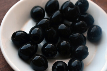 Pitted black olives on a white plate.
