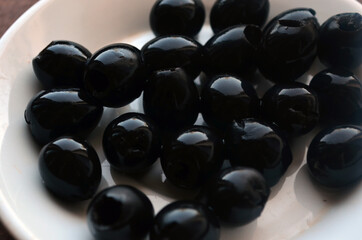 Pitted black olives on a white plate.
