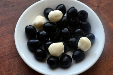Pitted black olives on a white plate.