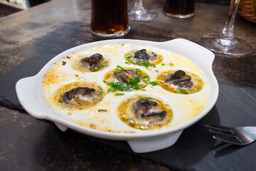Delicious French seafood appetizer - fresh escargot (snails) fried in a pan with garlic, butter and spices