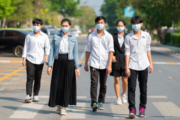 Healthcare concept - Group of Asian people walking in the city street and wearing Respiratory Protection Mask against covid19, anti-pollution, anti-smog, viruses.