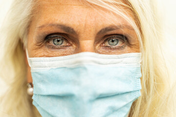 Close-up of Beautiful European woman wearing a protective face mask as a symbol of the coronavirus epidemic.