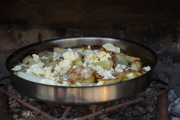 Potatoes with cream and lamb tissue under the sac. Sac  is a large metal or ceramic lid like a shallow bell with which bread dough or meat to be baked are covered.