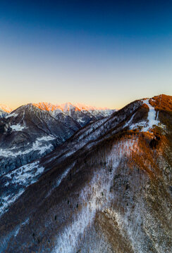 Aerial view by drone of ski slopes of Pian Delle Betulle and Alpe Paglio lit by sunset, Valsassina, Lecco province, Lombardy