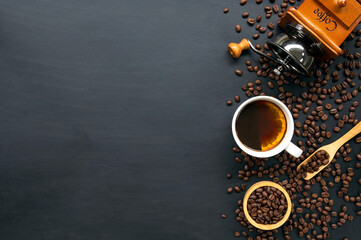 cup of coffee and bean on black wooden table background. top view