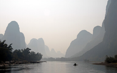 A hazy scene along the Li River between Guilin and Yangshuo in Guangxi Province, China. The karst...