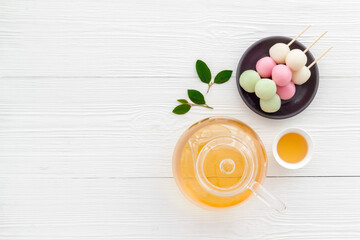 Naklejka na ściany i meble Japanese food background with sweets and tea. Three colored dumplings Dango