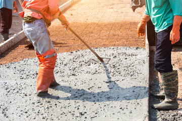 Workers are using tools to smooth the concrete floor.