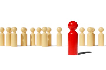 Single red wood figure standing out from a group of brown wood figures, leadership, standing out or bravery concept over white background