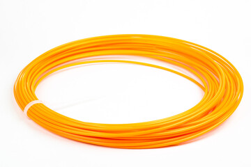 Top view of orange rolled filament plastic for 3D Printing Pen isolated on white.