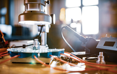 Modern microscope, connectors component and large green microcircuit in workshop laboratory