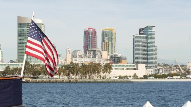Metropolis urban skyline, highrise skyscrapers of city downtown, San Diego Bay, California USA. Waterfront buildings near pacific ocean harbour. Star-Spangled Banner, Old Glory national flag waving.