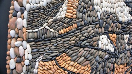 The stones are arranged in order create a beautiful patterns in black white and brown background.