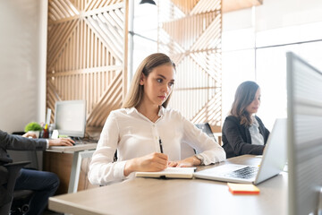 Businesswoman writing notes on notepad