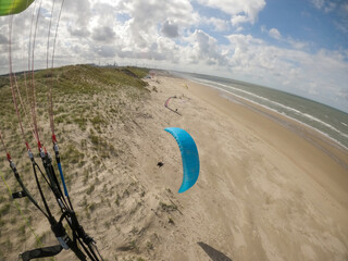 woman flying paraglider in Netherlands dunes