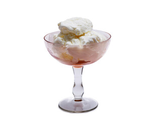 A bowl of white ice cream drizzled with jam and sprinkled with raspberries.