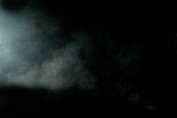 White smoke on a black background. Colored smoke with a blue tinge. The texture of scattered smoke. Blank for design. Layout for collages.