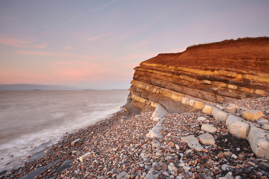 Evening light on rocks and the cliff at Kilve beach, Kilve, near Nether Stowey, Somerset, England