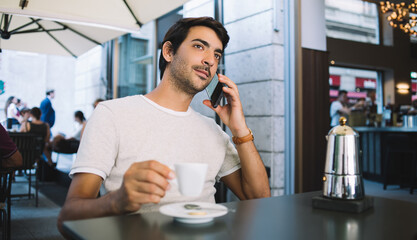 Pensive man talking on smartphone in cafe