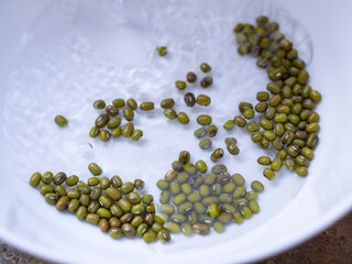 Mung bean seeds in water on a white background