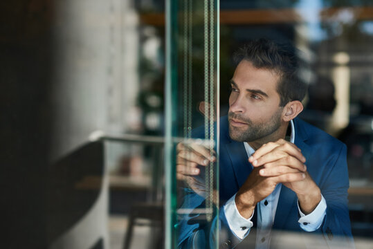 Young businessman sitting by a window inside of a cafe