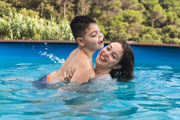 a girl catches a boy in the pool playing and splashing water
