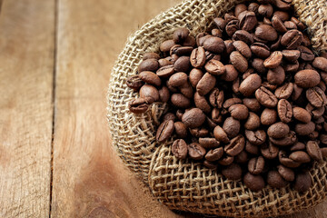 coffee beans in rustic bag rustic wooden background in top view with copy for text