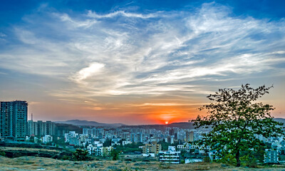 Sunset behind tall buildings in a rapidly growing city-Pune, Maharashtra, India.