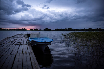 Naklejka premium sunrise over the lake when the sky is covered with rain clouds