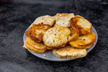 Pancakes on a plate on a dark background with place for text.
