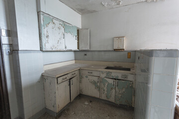 Angle view of cabinets and peeling paint in an abandoned hospital in the deep south