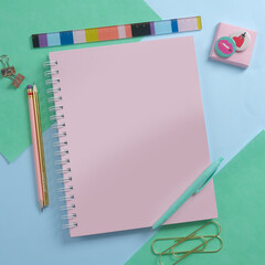 Cuaderno rosa con útiles, escritorio