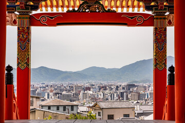View of the Kyoto skyline between temple columns from atop a hill in the city. Japanese...