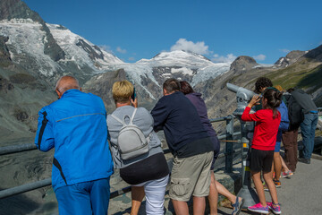 People viewing the diminishing Pasterze glacier on the grossglockner mountain range in Austria on a sunny day. Effects of global warming are a point of interest for people.