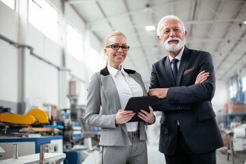 Man and woman discussing work. Colleagues working in factory.