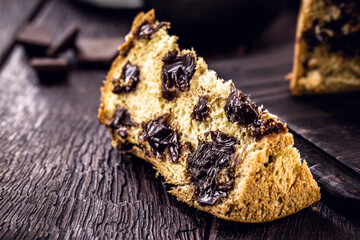 large slice of chocolate panettone, typical Brazilian dessert, on a rustic wooden table. Christmas candy