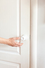 Spread of COVID-19 coronavirus by touching the door handle without antibacterial protection. A man's hand opens the door