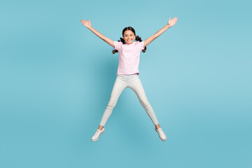 Fototapeta na wymiar Full length body size view of her she nice attractive pretty lovely cute glad successful cheerful cheery pre-teen girl jumping having fun free time leisure isolated over blue pastel color background