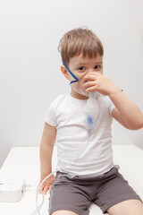 The boy makes inhalations. Treatment at home. Disease prevention