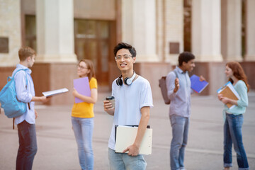 Asian Guy Standing Among Multiethnic Students Near University Building Outside
