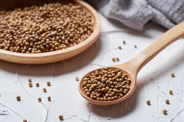 Coriander seed in a spoon on white background