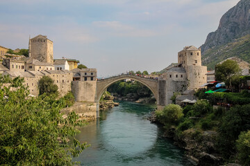 Obraz premium A landscape view of the old town of Mostar, with the old bridge over the river