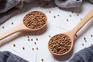 Coriander seed in a spoon on white background