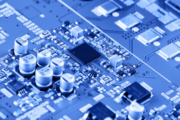 Electronic circuit board close up. Blue background.